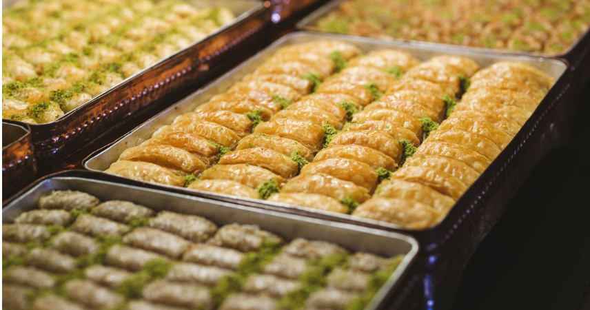 Turkish desserts: The magic of pistachio baklava lies in the contrast: shattering, paper-thin phyllo gives way to fragrant nut layers, while the sugar syrup binds everything into a sticky, golden brown masterpiece. Every bite delivers crunch, sweetness, and the earthy richness of roasted nuts in perfect harmony.
